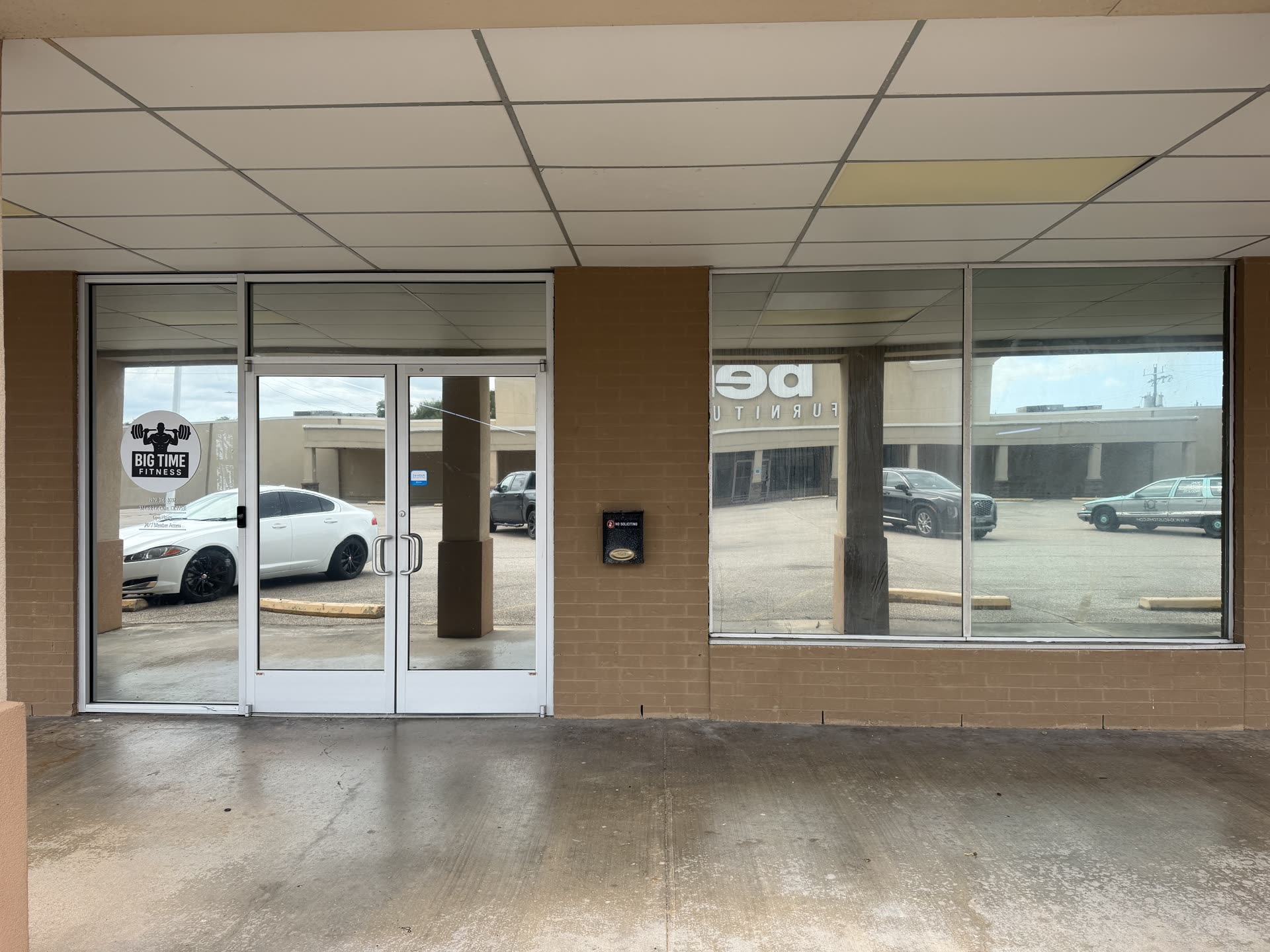 Inside Big Time Fitness in Clute, behind tinted storefront glass