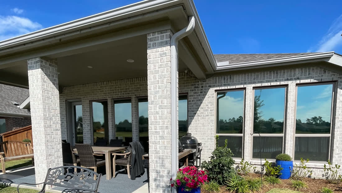 A covered back patio in Texas City with tinted doors and windows