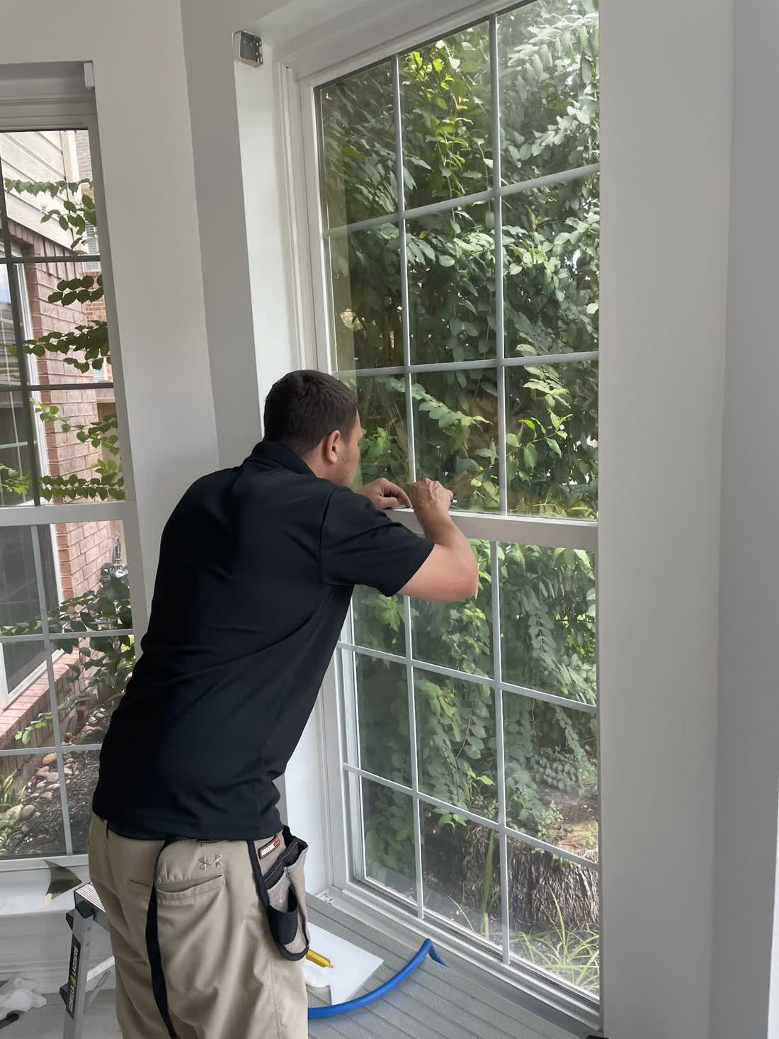 An installer squeegeeing film on a home window