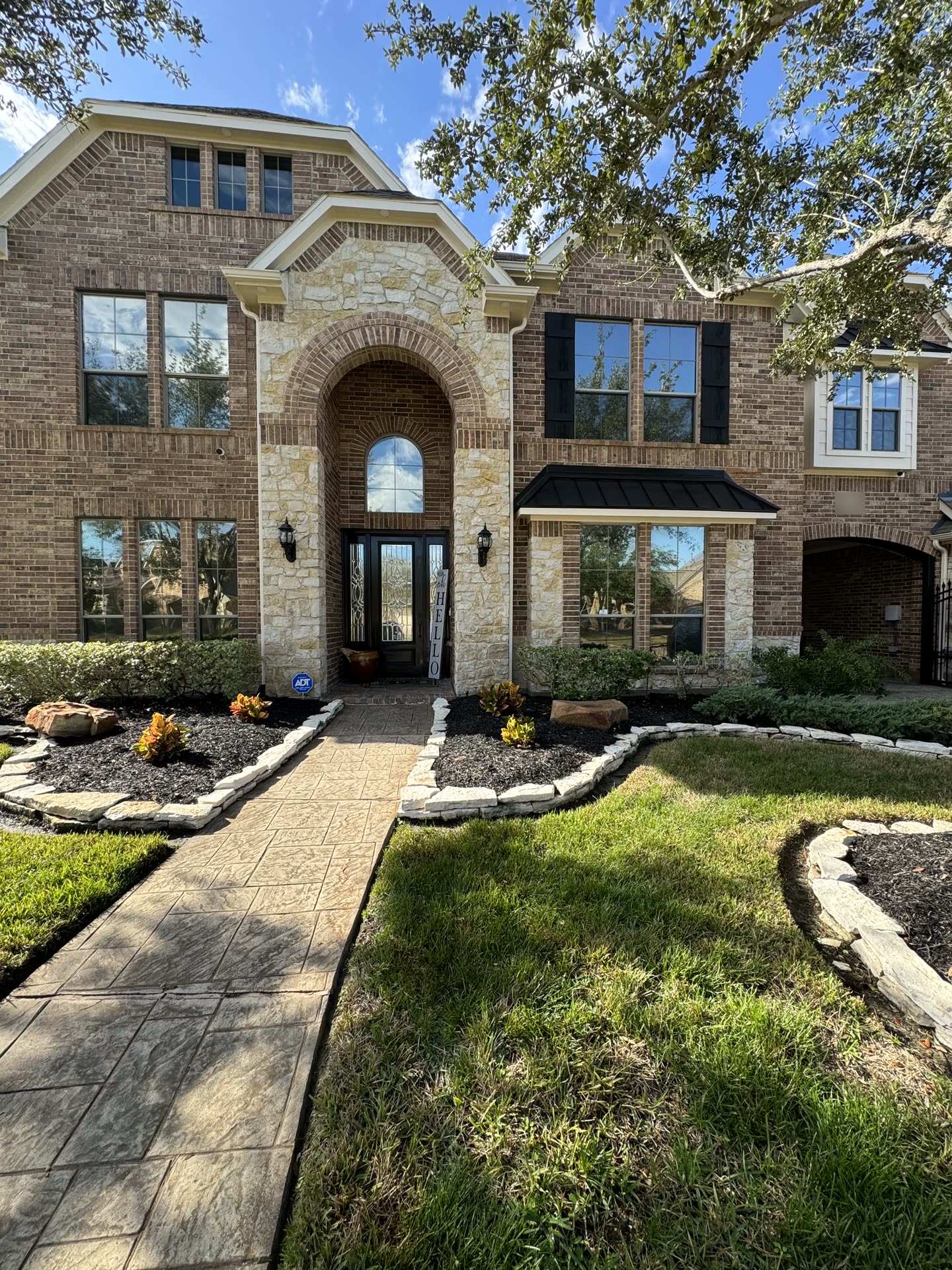 A two-story brick and stone home in Pearland with tinted windows